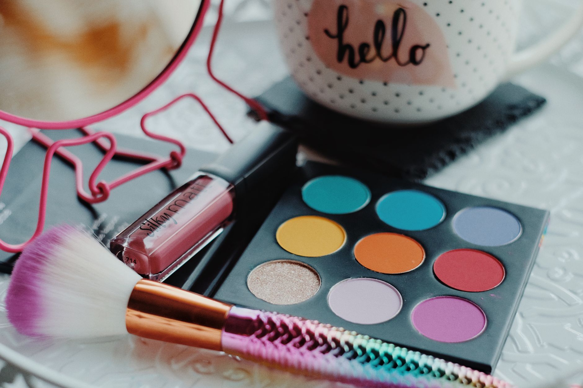 Palette de fards à paupières vibrante avec rouge à lèvres et pinceau, parfaite pour les passionnés de beauté.